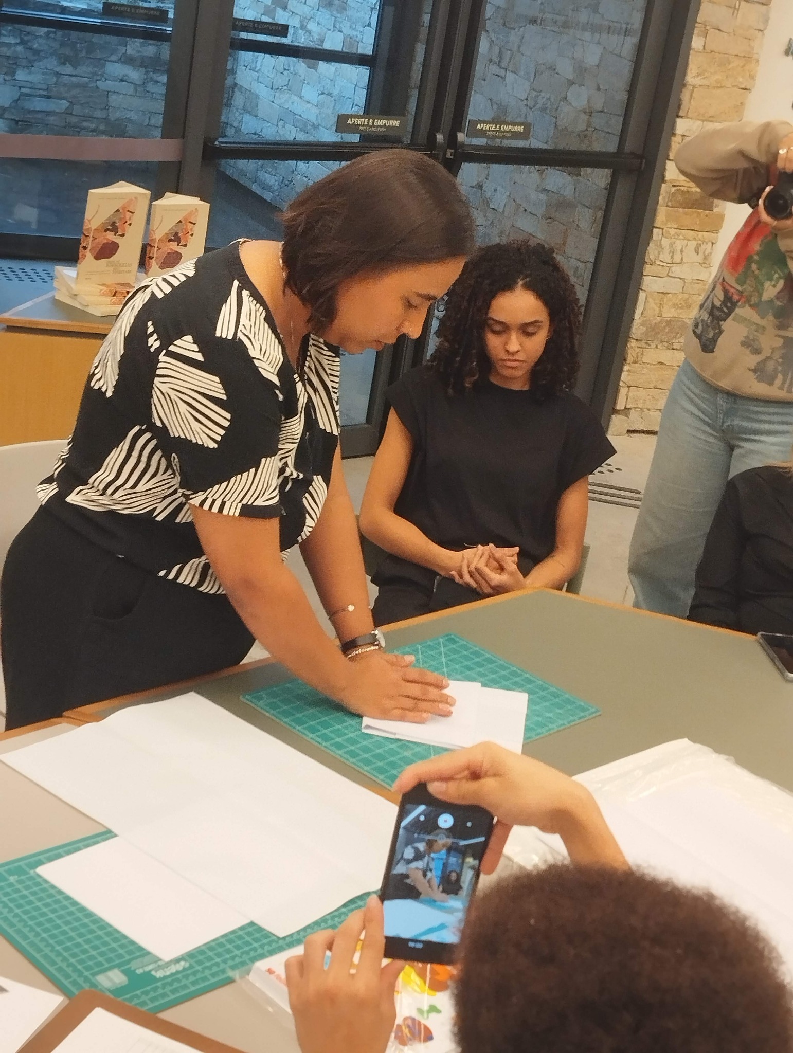 Karen Merlim orientando atividade prática com papel